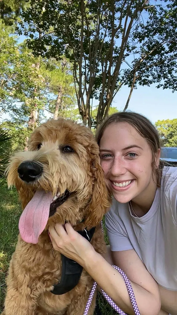 The owner of Woodlands Pet Retreat with a goldendoodle
